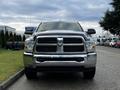 A 2012 RAM 3500 pickup truck with a shiny chrome grille and large front bumper is parked on a street facing the viewer