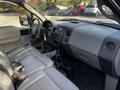 Interior of a 2008 Ford F-150 XL featuring gray leather seats a center console and dashboard controls