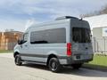 2019 Mercedes-Benz Sprinter van in gray with large windows and a high roof seen from the rear angle