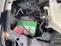 A green battery is visible in the engine compartment of a 2017 Chevrolet Express with various wires and components around it