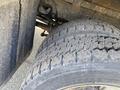 A close-up view of a worn tire on a 2003 Ford F-450 SD showing tread wear and dirt buildup on the surface