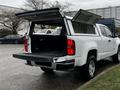 2019 Chevrolet Colorado with an open truck bed and a canopy raised showcasing the spacious cargo area