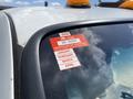 A 2010 Ford F-550 truck with a certification sticker on the windshield displaying approval details and expiration months