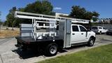 A 2019 RAM 3500 truck with a flatbed and equipment rack in the rear featuring multiple attaching points and a storage compartment on the side