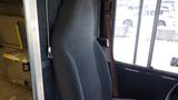 A gray fabric driver's seat of a 2011 Ford Econoline van visible from inside the vehicle