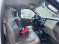 Interior view of a 2010 Ford F-550 showing the front seats dashboard and steering wheel with a red bag on the floor