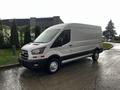 A 2020 Ford Transit van with a white body and black lower trim parked on the street with no visible load or markings