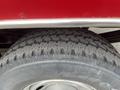 A close-up of a large tire from a 2011 Ford F-250 SD showcasing a deep tread pattern and silver rim