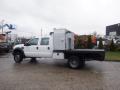 A 2009 Ford F-450 SD in white with a flatbed truck design and a metallic utility box mounted in the truck bed