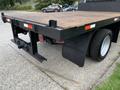 A 2012 Ford F-550 with a flatbed design showing the rear view highlighting the wooden surface and dual rear tires