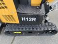 Close-up of a 2024 AGT Mini Excavator's undercarriage with a rubber track and the model designation H12R prominently displayed on the side