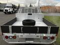 A 2014 Ford F-250 SD pickup truck with an open bed featuring a spare tire in the center and metal sides