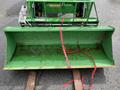 A 2003 John Deere 790 tractor with a rusty green front loader attachment secured with a red strap
