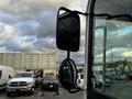 A 2007 Tennant Sentinel with a large side mirror reflecting cloudy skies