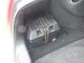 A black box secured with a strap inside the trunk of a car