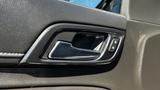 Close-up of the interior door handle of a 2018 Chevrolet Tahoe with a sleek design and control buttons for locking and unlocking the door