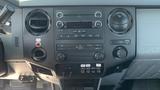 The interior dashboard of a 2011 Ford F-450 SD featuring radio controls air conditioning vents and various switches and knobs for vehicle functions