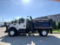 A 2007 International 7300 truck with a white cab and blue dump bed parked on a concrete surface