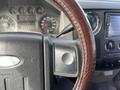 Close-up of the steering wheel and dashboard controls of a 2010 Ford F-550 with a leather-wrapped wheel and instrument cluster visible