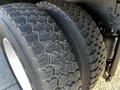 Close-up of two large tire treads on a 2013 International DuraStar 4300 showing substantial wear and a honeycomb pattern