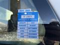 A blue and white vehicle inspection sticker with the title Certificate of Approval and a list of months and years for expiration displayed on a window