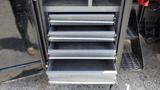 A set of five metal drawers stacked in a black cabinet attached to a 2014 RAM 5500 vehicle