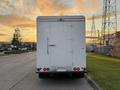 A 2017 Freightliner M Line truck viewed from the rear with a large white cargo box and red taillights