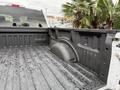 A 2018 Ford F-150 truck bed with a textured black liner showing some water droplets and a raised wheel well on one side