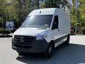 A white 2022 Mercedes-Benz Sprinter van with a large cargo area and black front grille parked in an outdoor setting