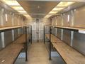 Interior of a 2006 Workhorse W42 with metal shelves and a metal floor showing empty shelving units and a rear door