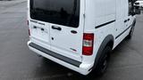 A white 2012 Ford Transit van with a black rear bumper and doors displaying no visible license plate