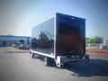 A 2013 Mitsubishi Fuso FE 160 box truck with a black cargo area parked with the back towards the viewer