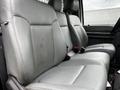 Interior seating of a 2011 Ford F-250 SD featuring grey leather seats with three seating positions and seatbelts