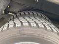 Close-up of a large truck tire with a rugged tread pattern designed for heavy-duty use typically found on a food truck