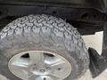 Close-up of a 2013 Chevrolet Silverado Hybrid tire showing deep treads and silver alloy wheel