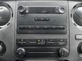 Dashboard of a 2011 Ford F-250 SD featuring radio controls climate control knobs and a digital clock display