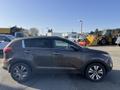 A 2012 Kia Sportage in gray color parked with its side facing the viewer showcasing its sleek design and alloy wheels
