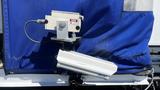 A camera mounted on a bracket attached to a blue fabric covering, used for surveillance or monitoring purposes