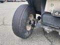 A close-up view of a worn tire on a 2000 Ez-go Industrial 800 showcasing its tread pattern and attached wheel assembly