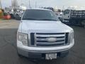 A 2009 Ford F-150 in white color with a chrome grille and license plate visible on the bumper