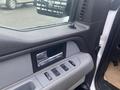 Interior door panel of a 2013 Ford F-150 featuring a silver handle and control buttons for windows and locks