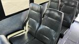 A set of black leather seats in a school bus interior designed for passenger comfort