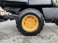 A yellow and black tire from a 1994 John Deere F1145 with a textured tread and mounted on a metal rim