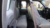 Interior view of a 2008 Ford F-650 showing two front seats and a rear bench seat in light gray fabric