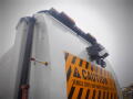 Close-up of a 2008 International 7400 truck showing a caution sign warning of frequent stops and backing with a mounted camera on the rear section of the vehicle