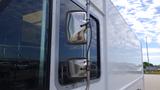 A 2011 Ford Econoline with shiny side mirrors attached to the driver's side door