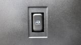 A fuel door release switch on a dark surface with an icon depicting a fuel pump