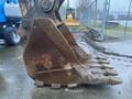 Close-up of a large metal excavator bucket with sharp teeth attached to a John Deere 350G construction machine