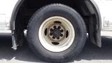 A close-up of a white wheel and tire from a 2011 Ford Econoline showing the tire tread and wheel rim details