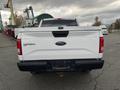 A white 2017 Ford F-150 truck viewed from the rear with the tailgate down and the Ford logo visible on the back